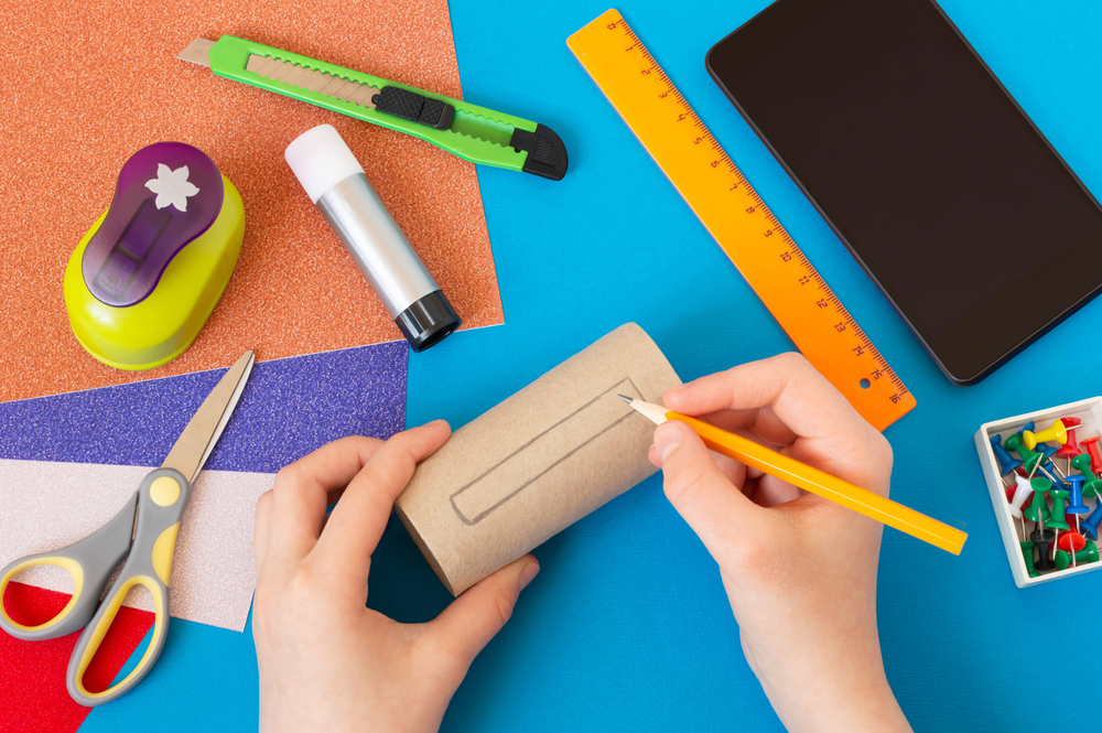 child using cardboard tube in arts and crafts