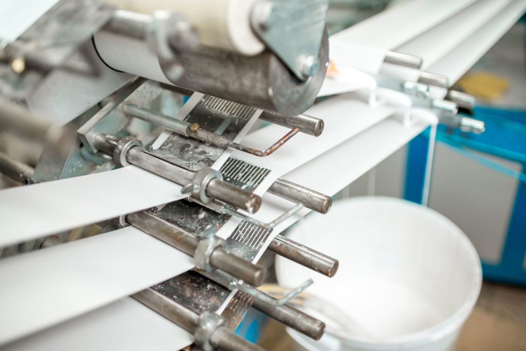 closeup of Production line of the machine which makes paper tube packaging