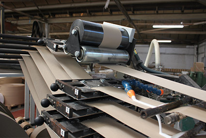 Cardboard being rolled out to be made into cardboard tubes